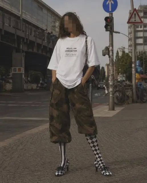 Model in the white ?Flat? Berlin Shirt and camouflage trousers crossing a Berlin street